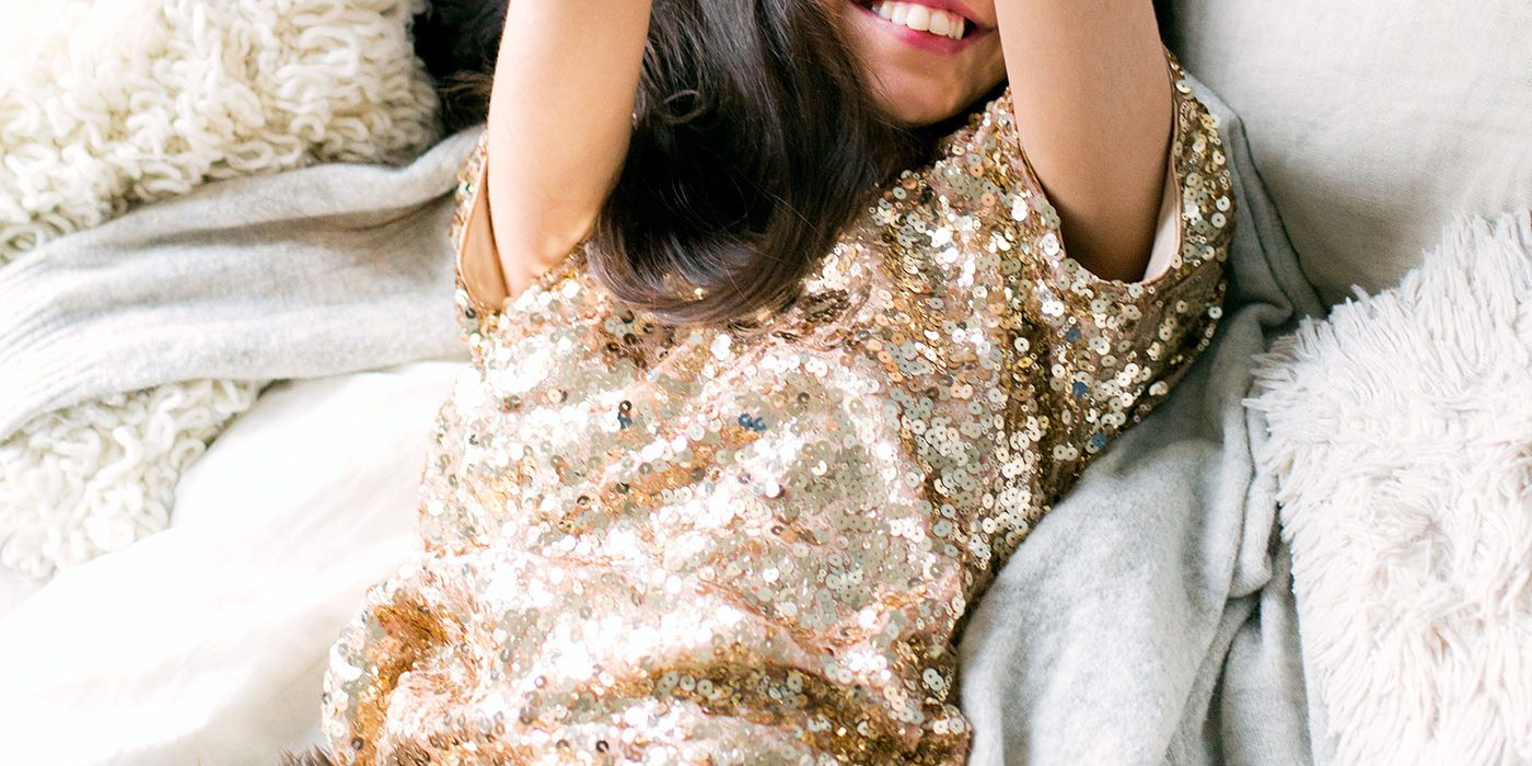 woman-wearing-brown-sequin-dress-laying-on-the-bed-698864